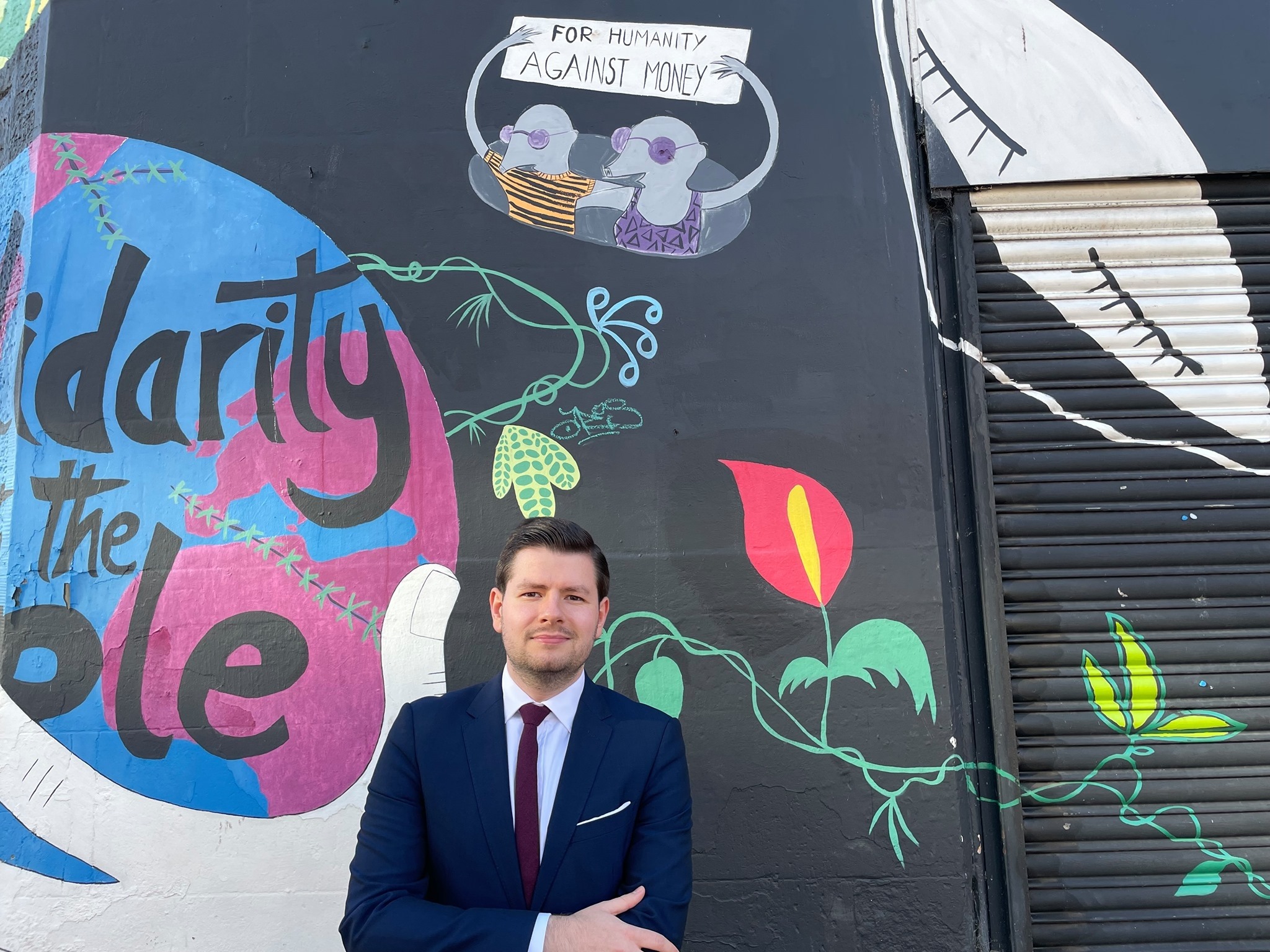 Councillor James Dalgleish standing in front of a mural